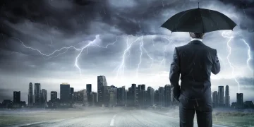 Man with umbrella under storm in the city.