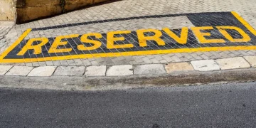 "RESERVED" parking spot painted on the ground.